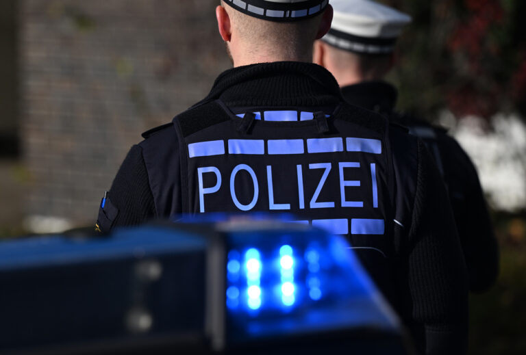 03.12.2024, Baden-Württemberg, Stuttgart: Das Logo der Polizei auf der Dienstkleidung eines Polizisten der vor einem Blaulicht steht (gestellte Szene). (zu dpa: «Mann fügt Frau mit Messer schwere Verletzungen zu») Foto: Bernd Weißbrod/dpa +++ dpa-Bildfunk +++ (KEYSTONE/DPA/Bernd Weißbrod)