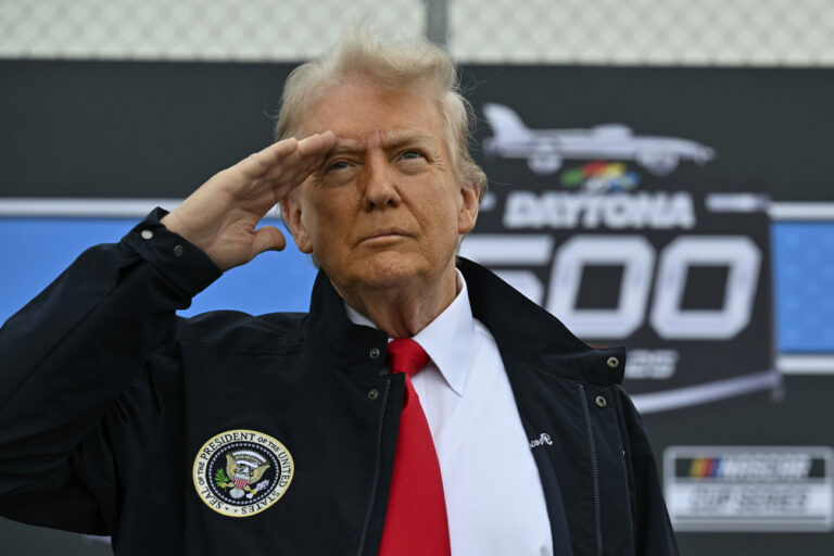 President Donald Trump salutes during a flyover as he attends the NASCAR Daytona 500 auto race at Daytona International Speedway, Sunday, Feb. 16, 2025, in Daytona Beach, Fla. (Pool via AP)