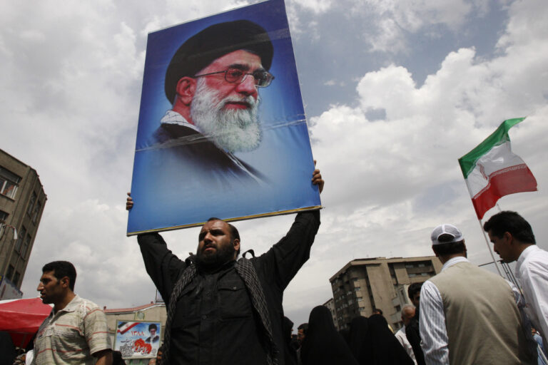 An Iranian man holds a poster of the supreme leader Ayatollah Ali Khamenei at the conclusion of the Friday prayers, in Tehran, Iran, Friday, June 19, 2009. Iran's supreme leader said Friday that the country's disputed presidential vote had not been rigged, sternly warning protesters of a crackdown if they continue massive demonstrations demanding a new election. (AP Photo/Vahid Salemi)