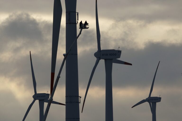 Technicians are seen at a wind mill near Husum, northern Germany, on Wednesday, Jan.13, 2009. (AP Photo/Heribert Proepper)