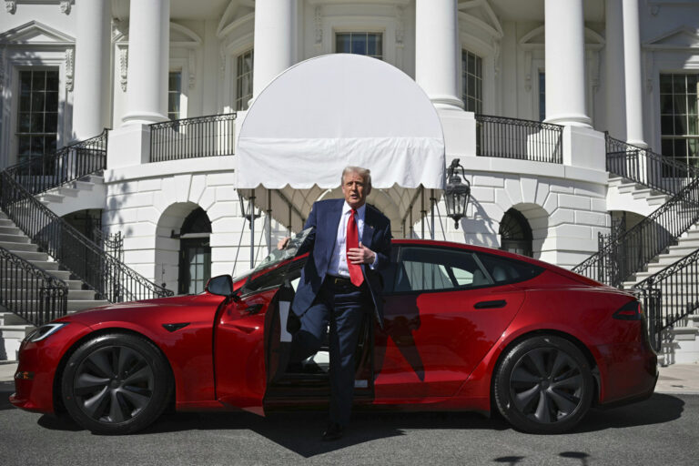 President Donald Trump steps out of a red Model S Tesla vehicle on the South Lawn of the White House Tuesday, March 11, 2025, in Washington. (Pool via AP)