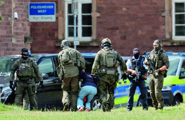 epa11564011 Federal Police officers lead the Solingen knife attack suspect out of the helicopter to his arraignment at the Federal Supreme Court (BGH) in Karlsruhe, Germany, 25 August 2024. The man, who stabbed passers-by at random with a knife during the city festival in Solingen, turned himself in to a police patrol on the evening of 24 August, police said. North Rhine-Westphalia's interior minister Herbert Reul announced late on 24 August that 'the man we've really been looking for the whole day has just been taken into custody.' Three people have been killed and eight others injured, five of them seriously, in the knife attack on 23 August, according to the police. EPA/RONALD WITTEK